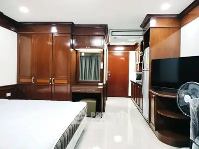 Spacious bedroom with wooden furniture and modern amenities in a stylish apartment.