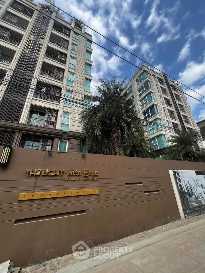 Modern condominium building with palm trees and clear blue sky