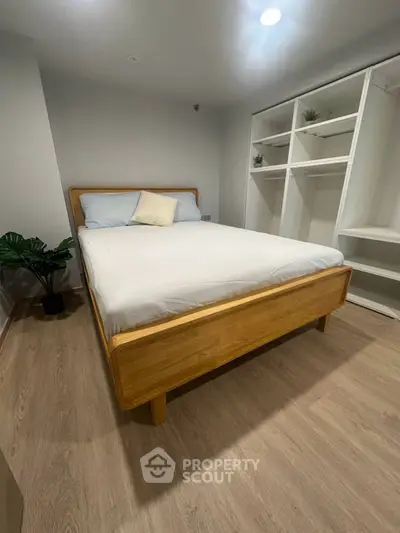 Modern bedroom with wooden bed frame and built-in closet, perfect for cozy living.