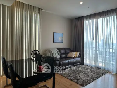 Modern living room with large windows and stylish decor in a high-rise apartment.