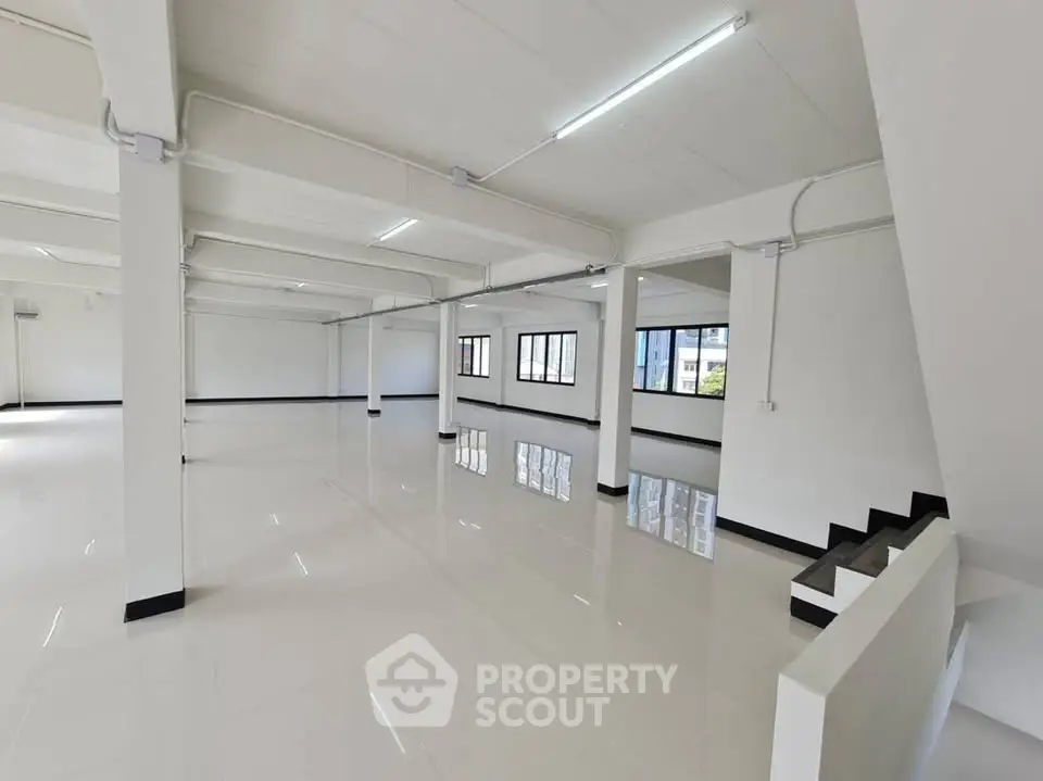 Spacious open-plan commercial space with large windows and glossy flooring, ideal for offices or retail.