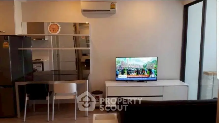 Modern living room with sleek furniture and wall-mounted TV in a stylish apartment.