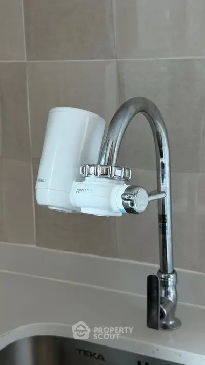 Modern kitchen faucet with water filter installed, enhancing water quality in a contemporary kitchen setting.