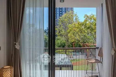 Spacious balcony with serene garden view in modern apartment