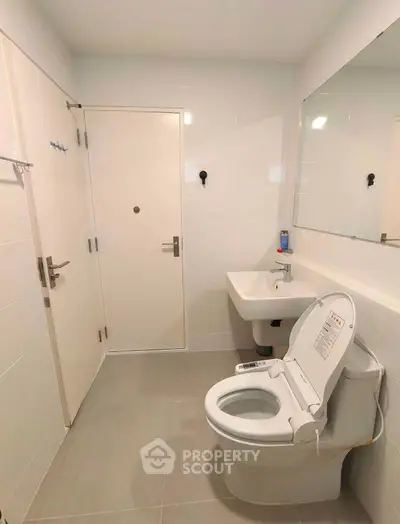 Modern bathroom with sleek fixtures and smart toilet in a contemporary home.