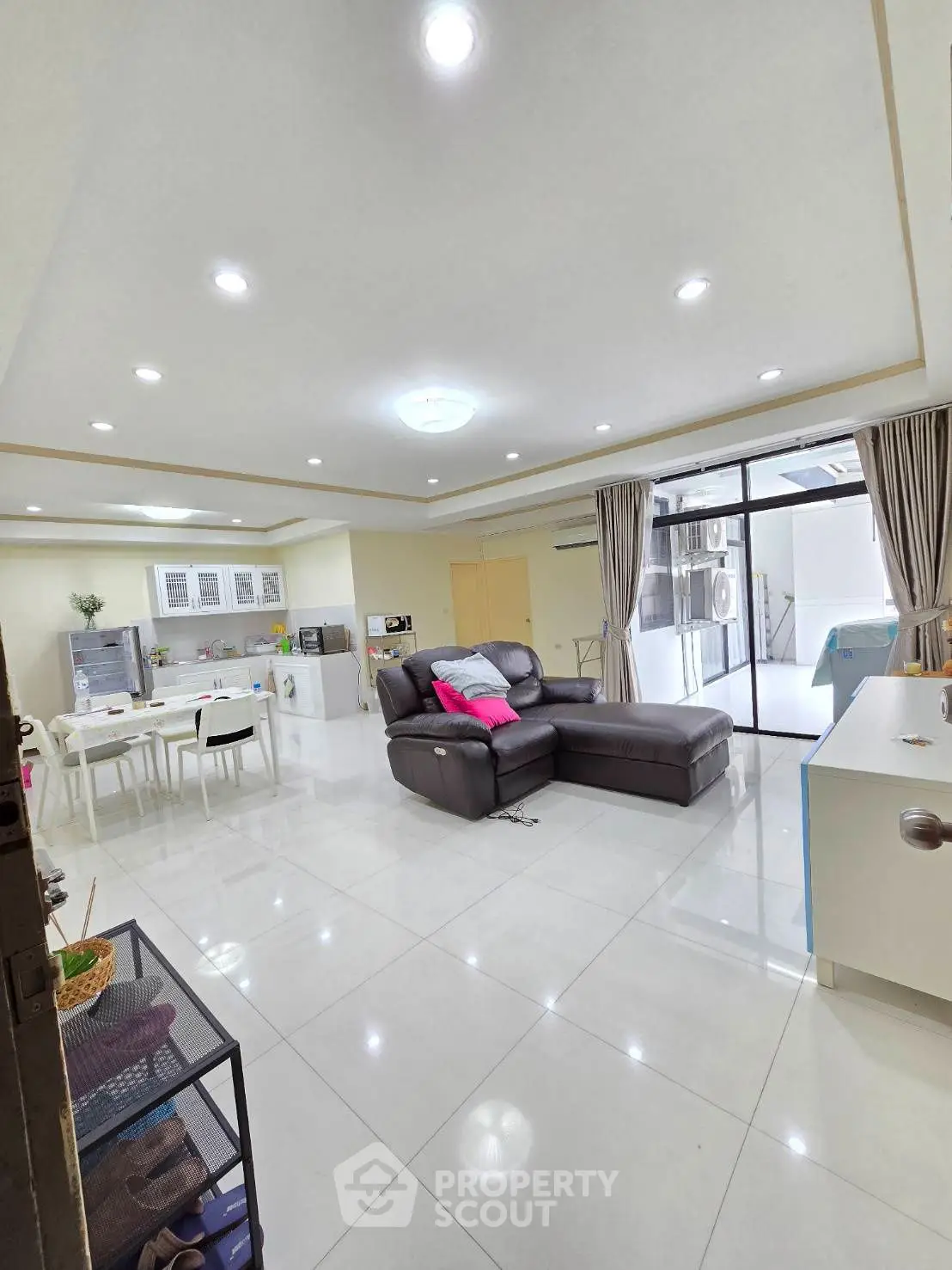 Spacious modern living room with open kitchen and sleek leather sofa