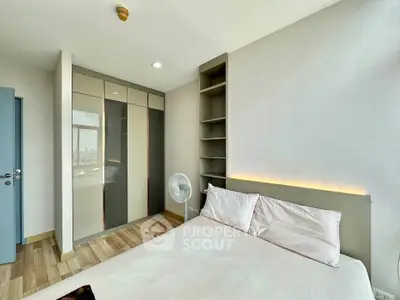 Modern bedroom with built-in wardrobe and stylish lighting in a high-rise apartment.