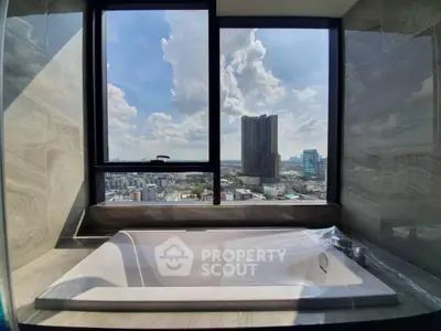 Luxurious bathroom with stunning city view from high-rise apartment window.