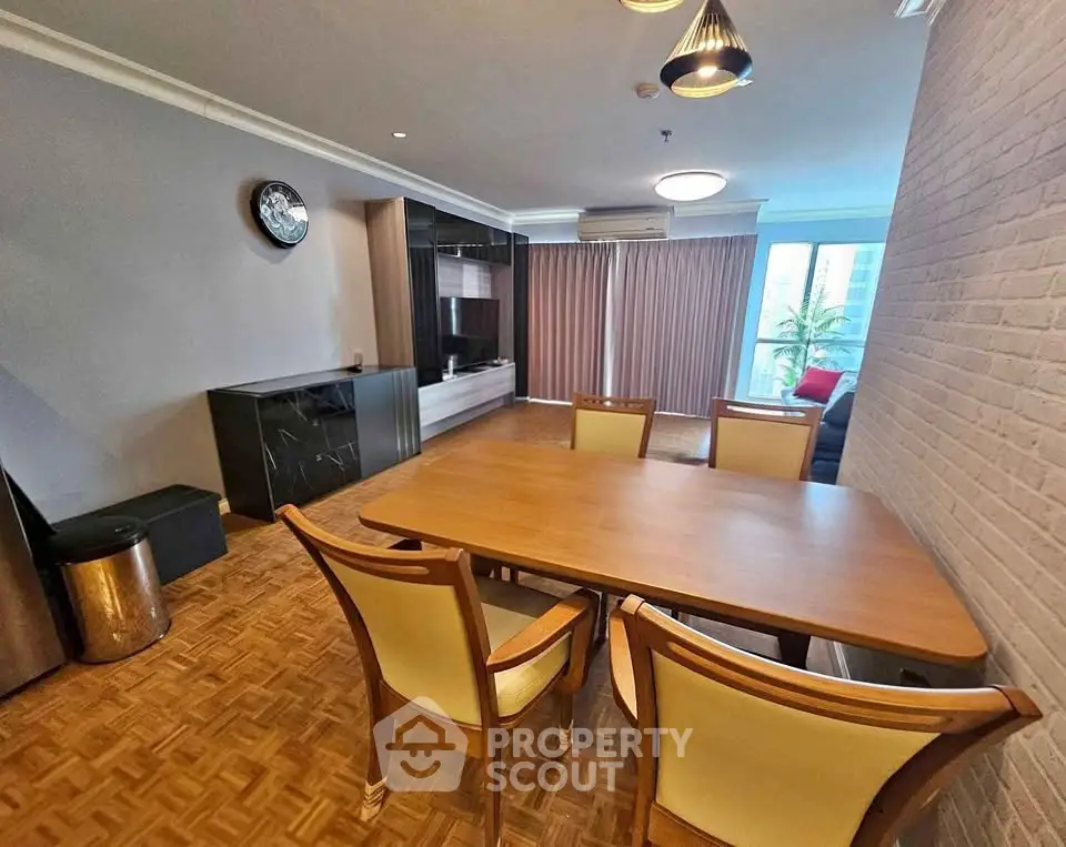 Spacious dining area with elegant wooden table and chairs, featuring modern decor and natural light.