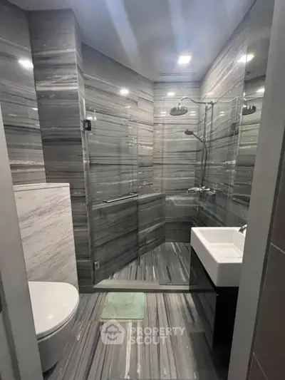 Luxurious modern bathroom with sleek glass shower and elegant marble tiles