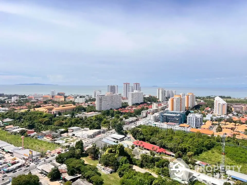 Stunning aerial view of coastal cityscape with modern high-rise buildings and lush greenery.