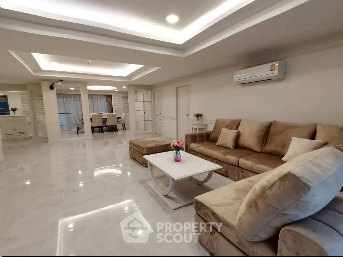 Spacious modern living room with elegant beige furniture and open dining area