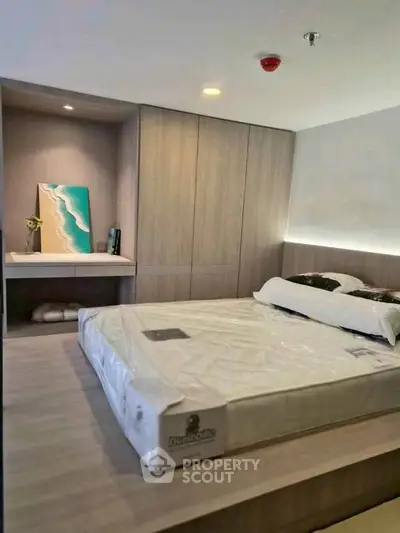 Modern bedroom with sleek design and built-in storage, featuring a stylish bed and ambient lighting.