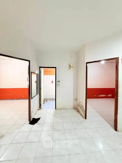 Spacious interior with tiled floors and multiple rooms, ideal for renovation or customization.
