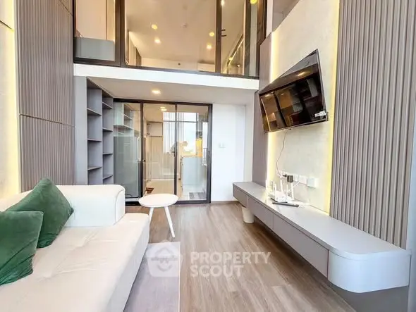 Modern living room with high ceiling and mezzanine, featuring sleek design and contemporary furniture.