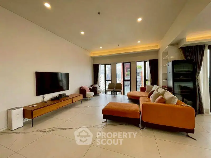 Spacious modern living room with stylish furniture and large windows offering natural light.