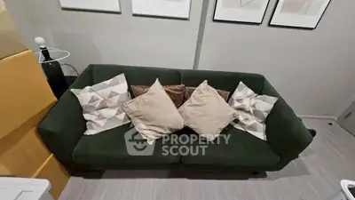 Stylish living room with modern green sofa and decorative pillows, perfect for cozy relaxation.