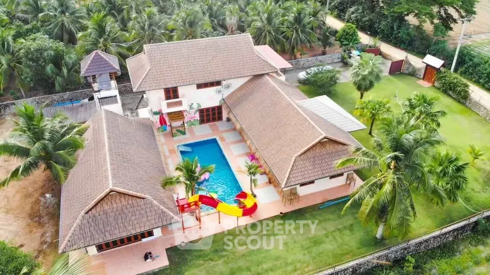 Stunning aerial view of luxurious villa with private pool and lush garden, perfect for tropical living.