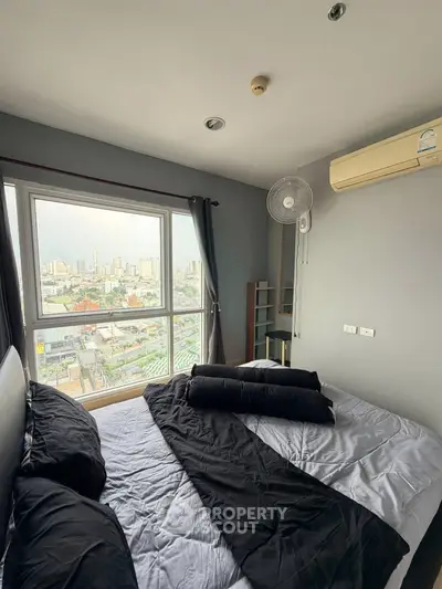 Modern bedroom with city view, featuring large window and air conditioning, perfect for urban living.