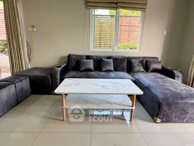 Spacious living room with plush gray sectional sofa and elegant marble coffee table.