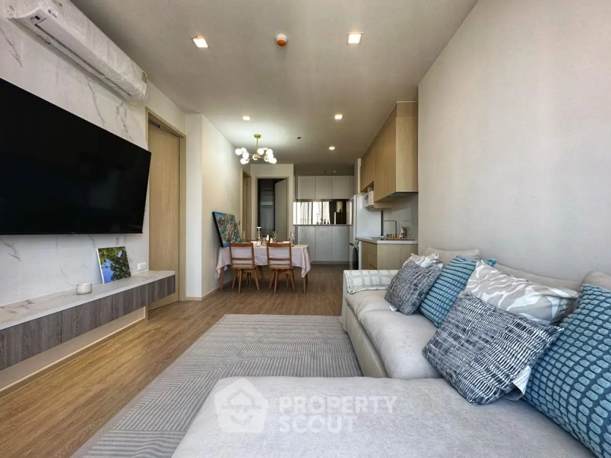 Modern open-plan living room and kitchen with stylish decor and cozy seating area.