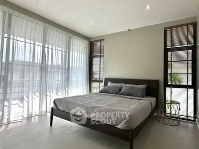 Spacious bedroom with large windows and modern decor