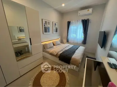 Modern bedroom with stylish decor, featuring a cozy bed, sleek wardrobe, and air conditioning for ultimate comfort.