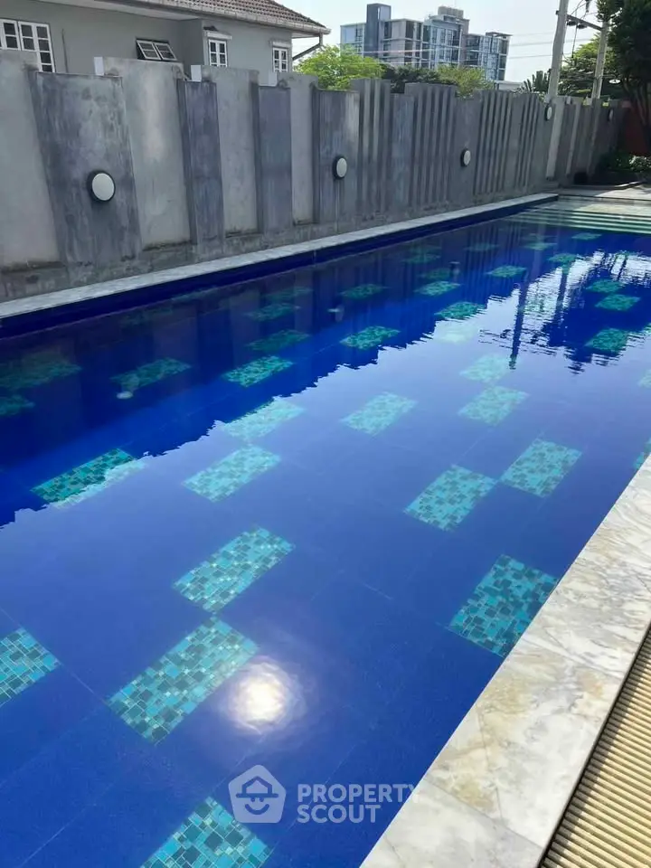 Luxurious outdoor swimming pool with modern design and serene ambiance in a residential complex.