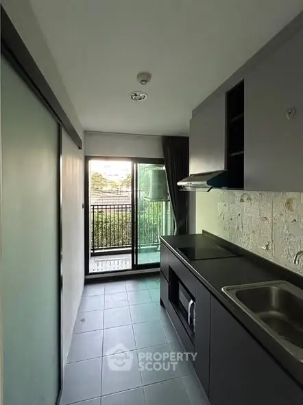 Modern compact kitchen with sleek design and balcony view