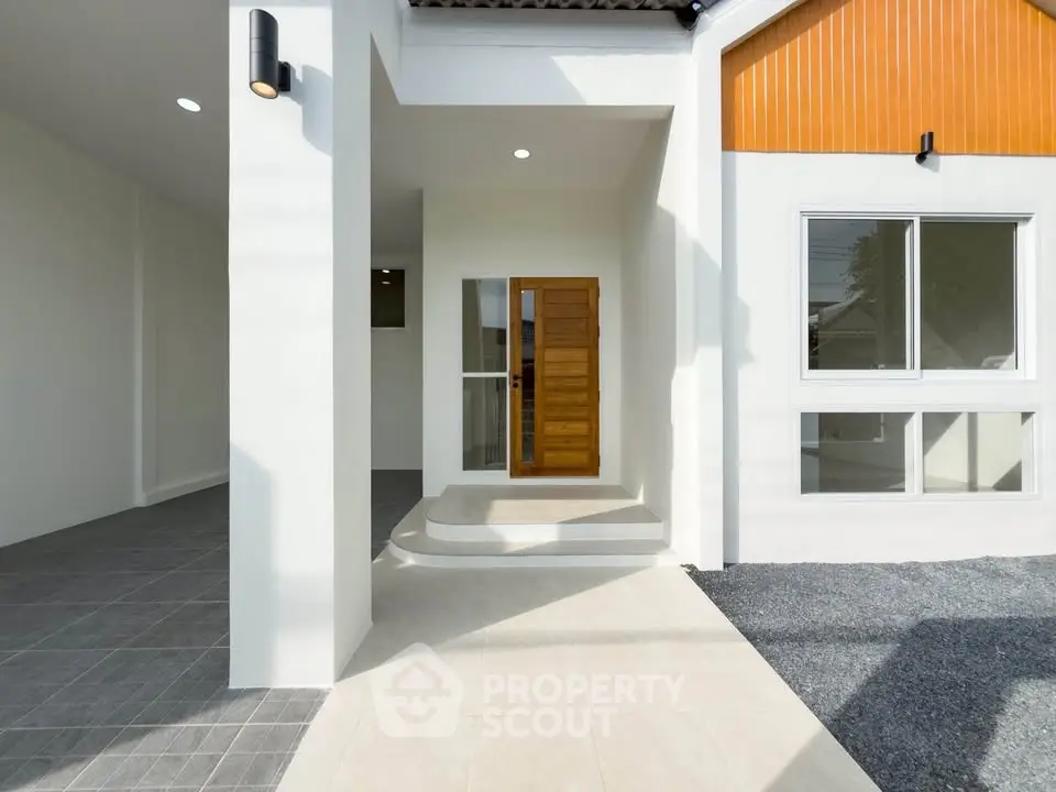 Modern home entrance with wooden door and sleek exterior design