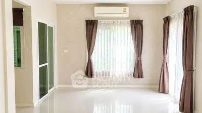 Bright empty living room with large windows and air conditioning unit