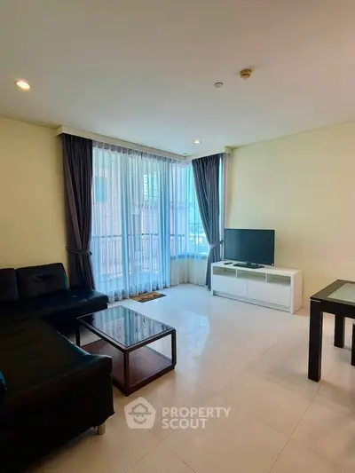 Spacious living room with modern furniture and large windows in a stylish apartment.