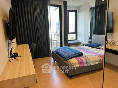 Modern bedroom with city view, featuring sleek furniture and large windows for natural light.