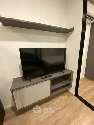 Modern living room with sleek TV unit and wooden flooring