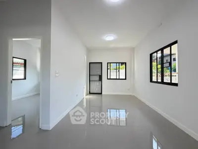 Spacious modern living room with glossy floors and large windows for natural light.