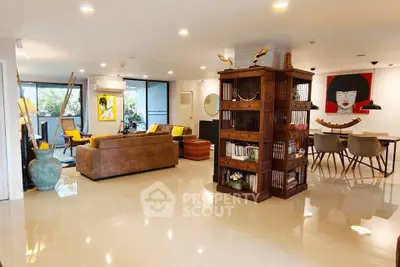 Spacious modern living room with elegant decor and open layout, featuring stylish furniture and art pieces.