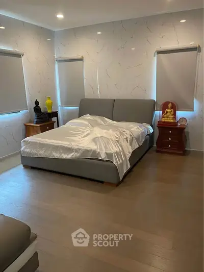 Spacious bedroom with modern decor and natural light, featuring a comfortable bed and stylish furnishings.