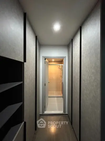 Modern hallway leading to a sleek bathroom with shower