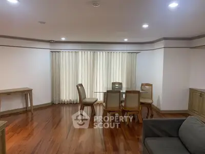 Spacious living room with wooden flooring and elegant dining set