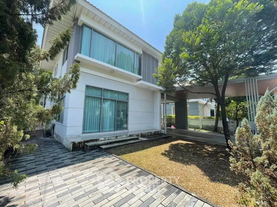 Modern two-story house with large windows and lush greenery, perfect for family living.