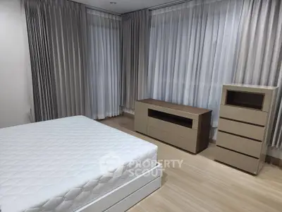 Spacious bedroom with modern furniture and elegant curtains, perfect for a serene living experience.