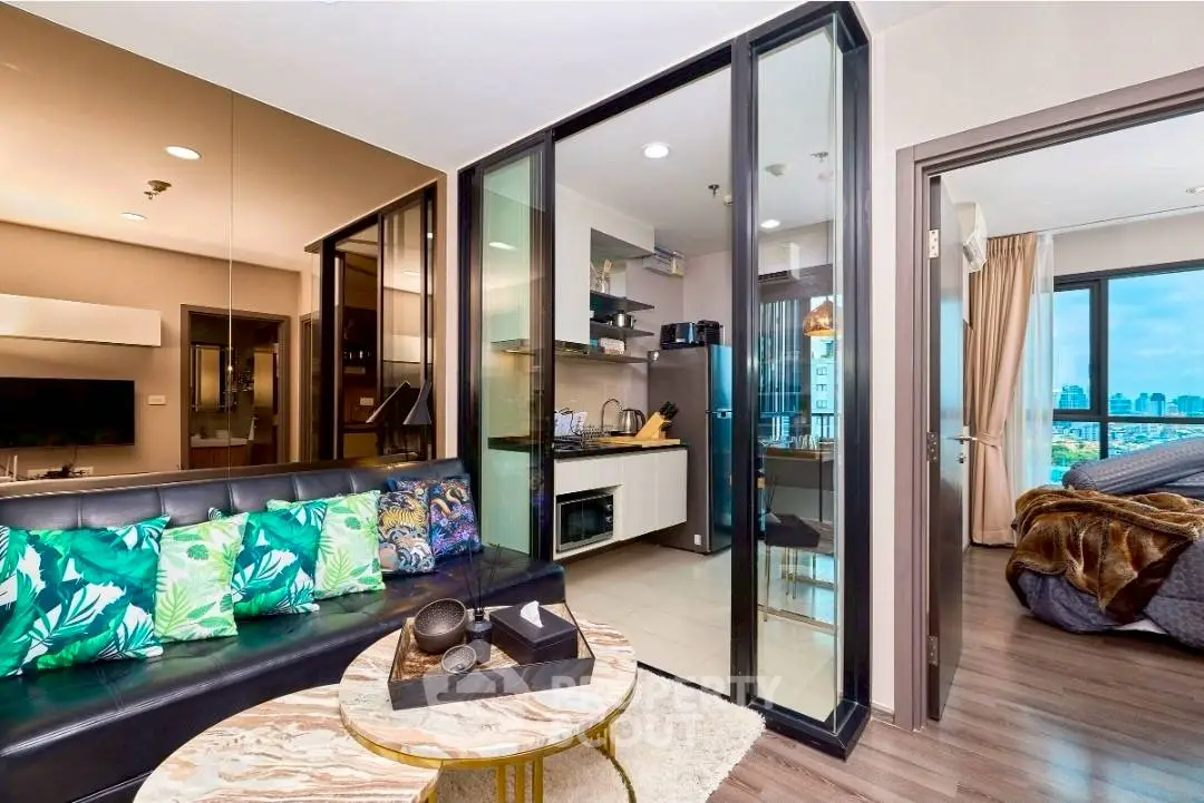 Modern apartment with open living room, kitchen, and bedroom featuring city view.