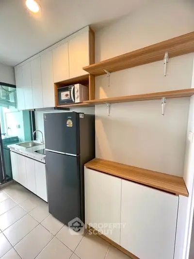 Modern kitchen with sleek cabinetry and stainless steel appliances in a contemporary apartment.