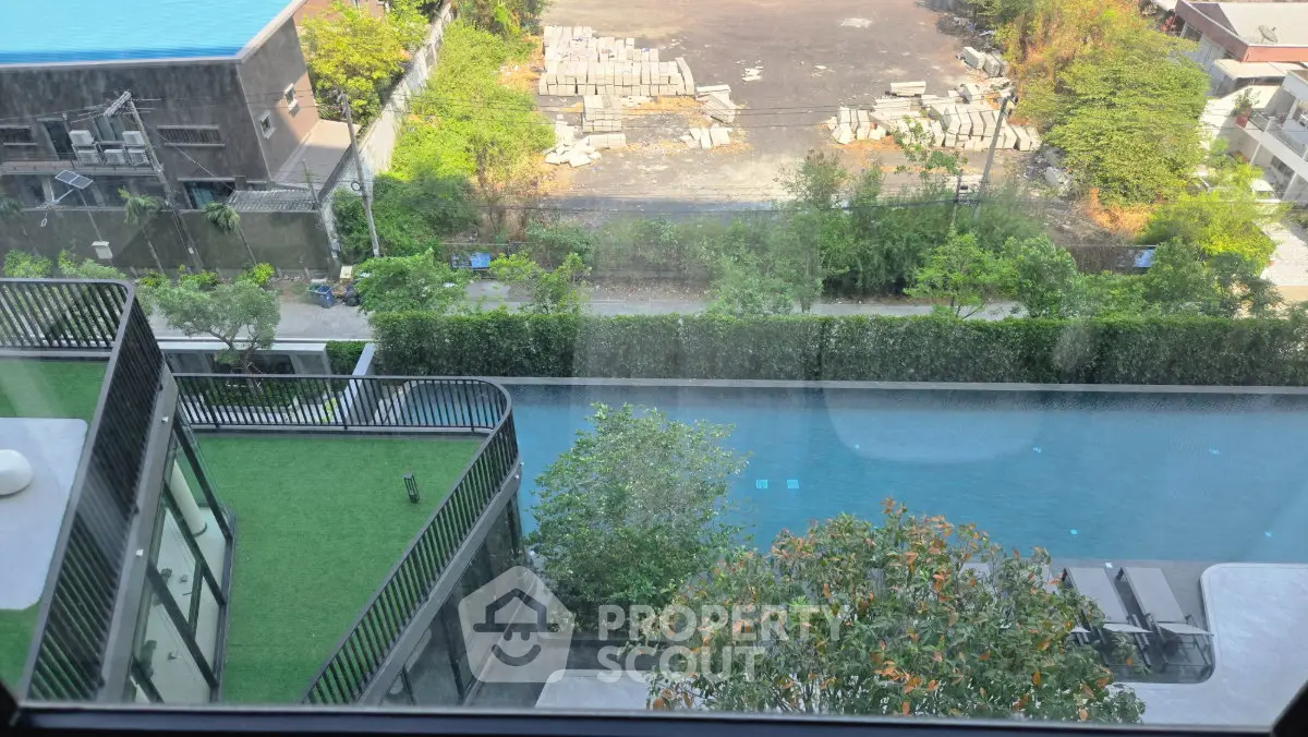 Stunning aerial view of modern building with pool and lush greenery, perfect for luxury living.