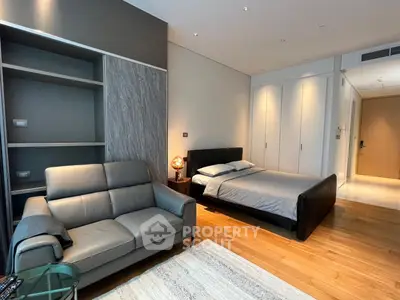Modern studio apartment with sleek design, featuring a cozy bed, stylish sofa, and built-in storage.