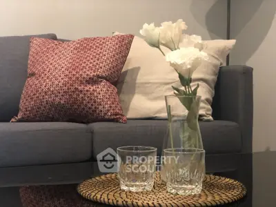 Stylish living room with cozy sofa, decorative pillows, and elegant floral arrangement.