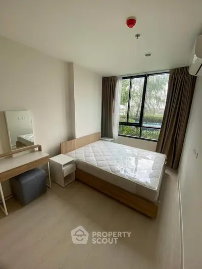 Modern bedroom with large window and minimalist furniture in a bright apartment