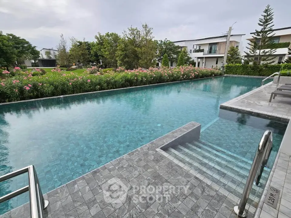 Luxurious residential pool with lush garden and modern architecture, perfect for relaxation and leisure.