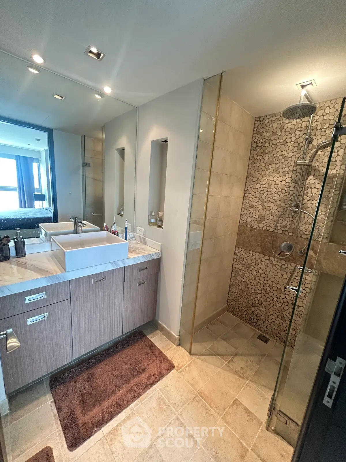 Modern bathroom with elegant shower and stylish vanity in luxury apartment.