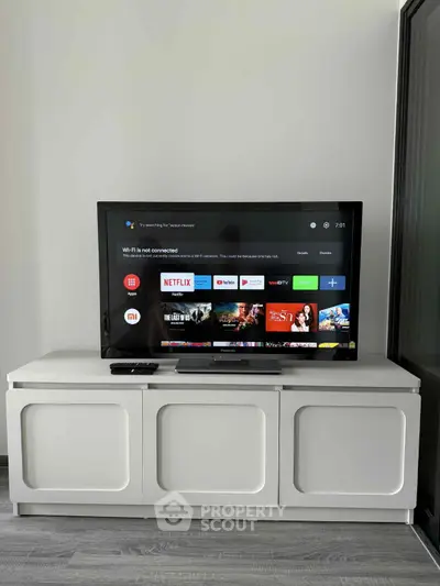 Modern living room with sleek TV setup on stylish white cabinet, perfect for entertainment enthusiasts.